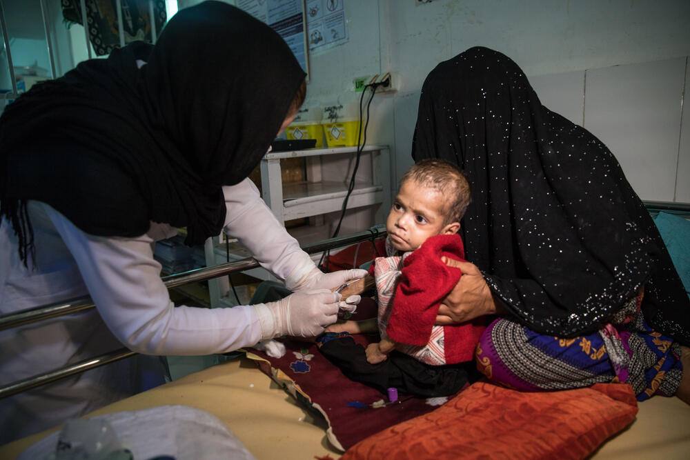 A nurse carries out a blood test for three-year-old Taqwa, being treated for anaemia, tuberculosis and malnutrition