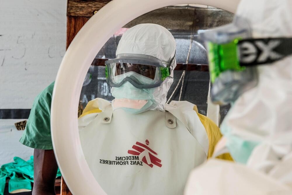 A staff member prepares to enter the isolation area at the MSF Ebola treatment center in Nongo, Guinea.