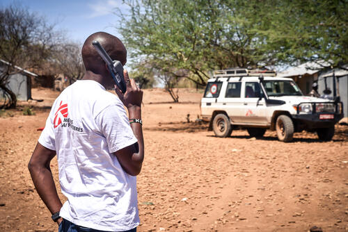 An MSF staff member uses a satellite phone to make a call