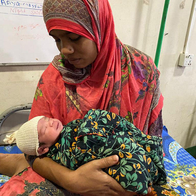 A mother cradles her new baby at an MSF maternity unit in Bangladesh