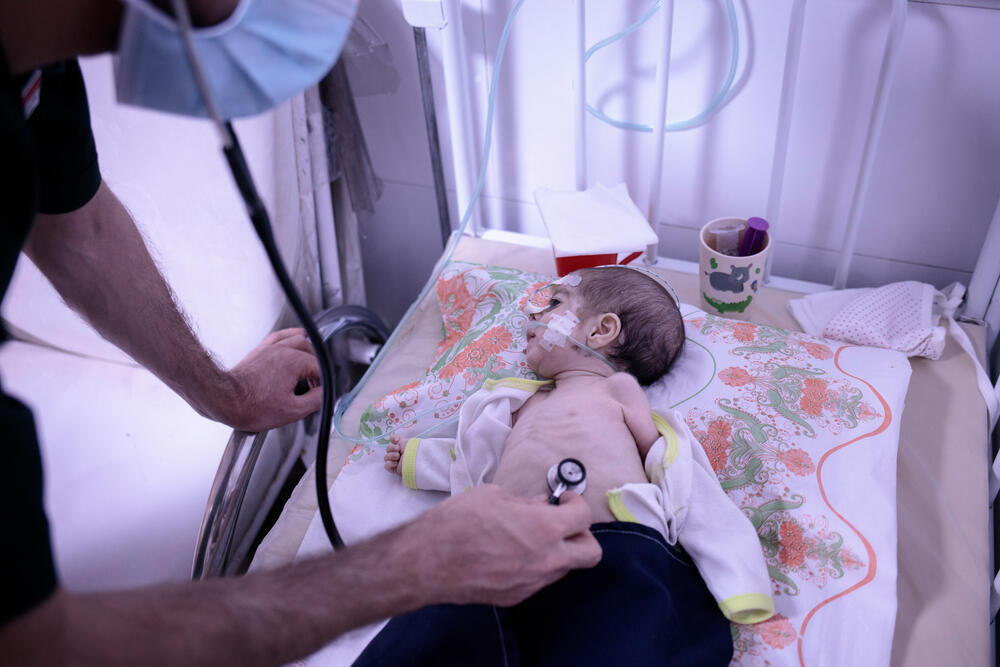 An MSF medic checks on a young child at a feeding centre in Herat