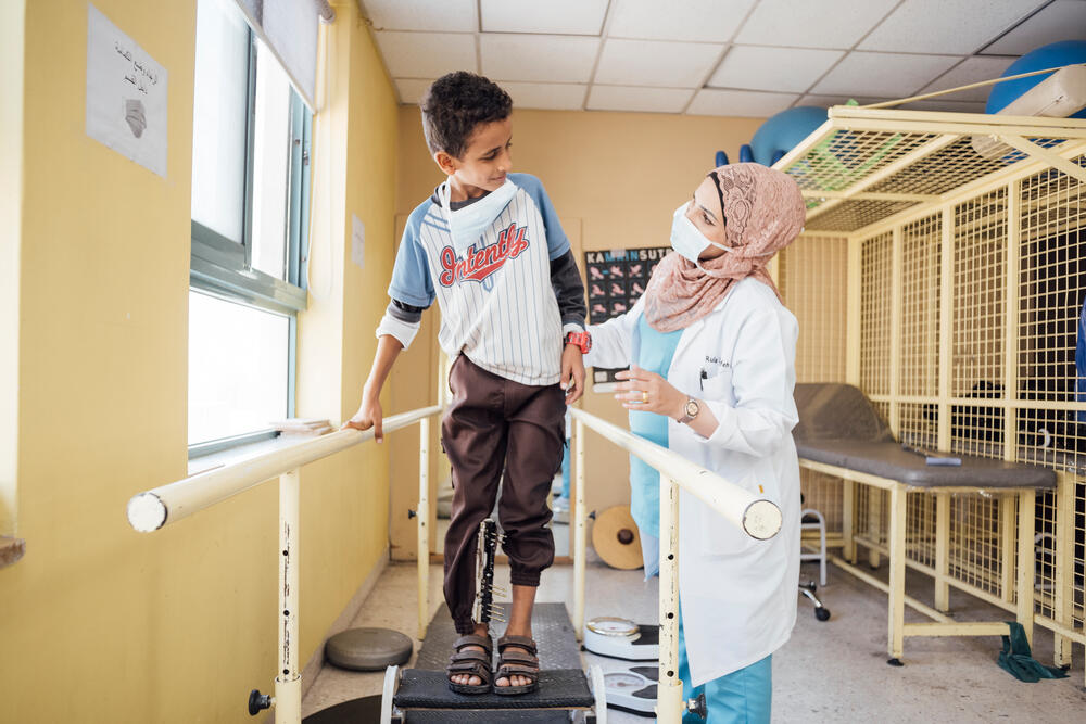 With the support of MSF physiotherapist Rula Marahfeh, 11-year-old Ahmed Darwesch learns how to walk again after being injured in an explosion in Yemen, 2021. 