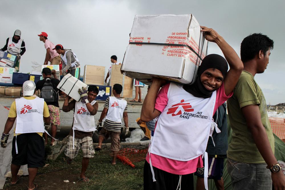 MSF logisticians and daily workers unload a truck with humanitarian supplies in the aftermath of Typhoon Haiyan