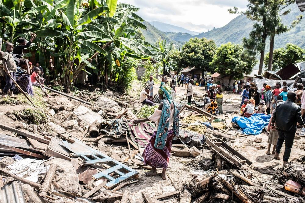 Marie, 32 years old, walks through the rubble of her home destroyed by floods in Nyamubuki
