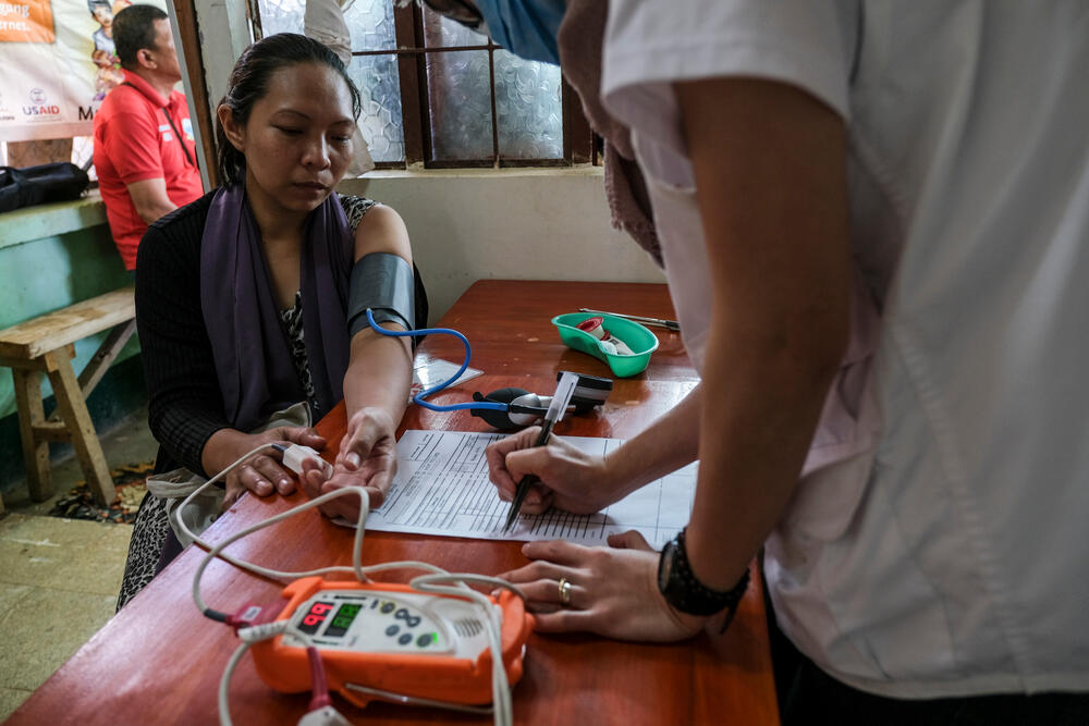 A patient in the Philippines has her blood pressure and heart rate measured