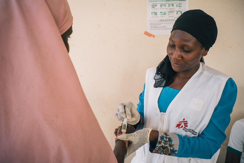 A member of MSF's Nigeria Emergency Response Unit (NERU) attends to a woman in the meningitis treatment centre run by MSF in Sokoto, Nigeria.