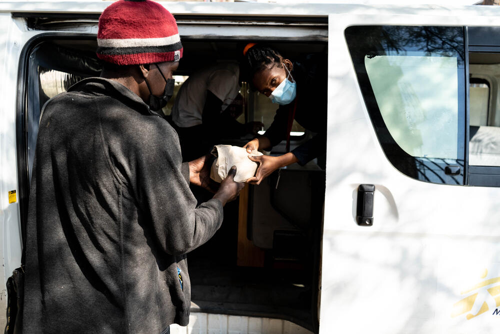 Selma, an MSF fieldworker, hands a client of the Mafalal project a pre-packaged injection kit from an MSF vehicle. The kits are part of MSF's harm reduction programme and reduce the risks drug users face from re-using contaminated needles.
