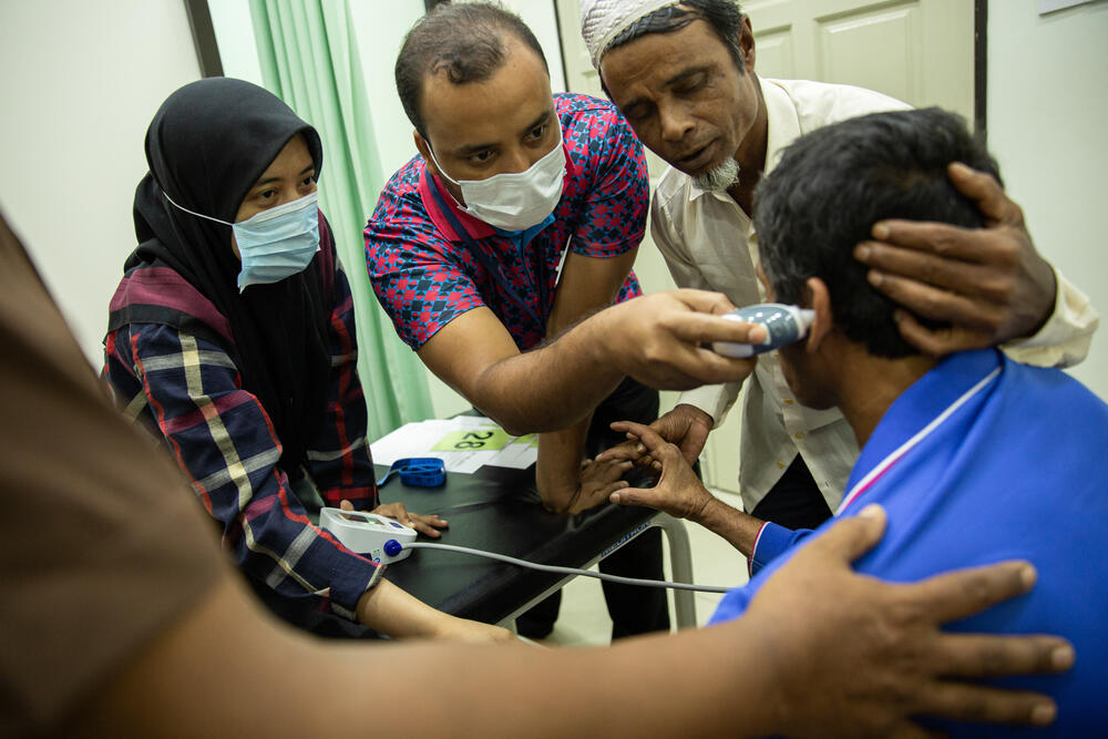Kairul, a Rohingya refugee is examined by MSF nurses after falling two floors while working at a construction date