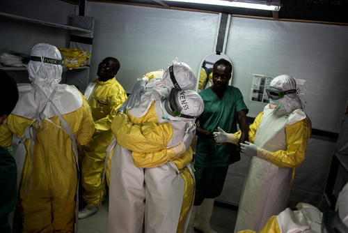 Health workers embrace whilst putting on their personal protective equipment(PPE) before heading into the red zone at a newly build MSF supported ebola treatment centre(ETC) on November 07, 2018 in Bunia.