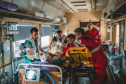 A severely war-wounded patient is moved from an ambulance stretcher to a bed inside the intensive care unit (ICU) of the MSF medical train, which transports war wounded and seriously ill people from eastern Ukraine to Lviv, in western Ukraine, where they can receive the specialsed care that they need.