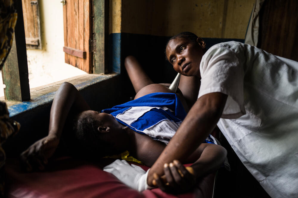 Sylvie Grengbo, the midwife at the Nzacko health centre, listens to a baby's heartbeat