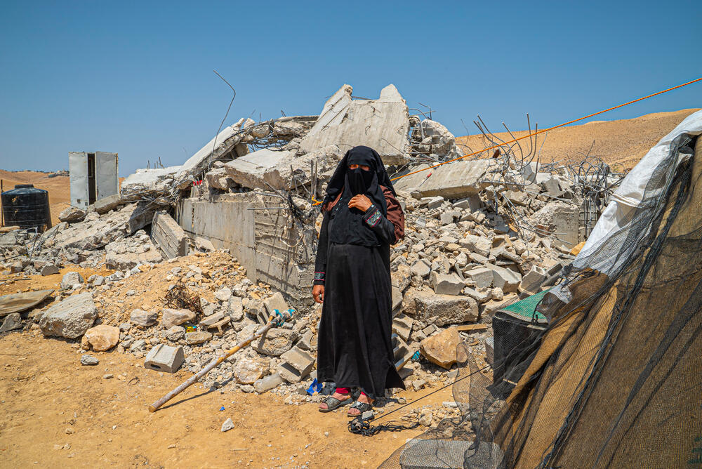 Resident Sara stands next to her son's house, demolished in July 2022