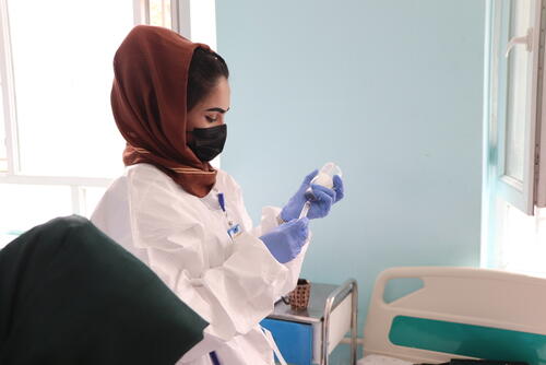 Photo of an MSF nurse drawing measles medication