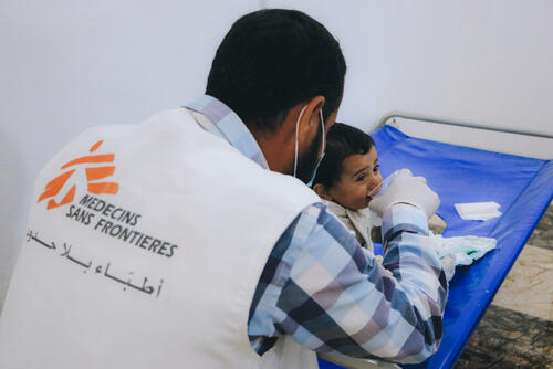 An MSF doctor giving oral rehydration solution to a young cholera patient in Idlib