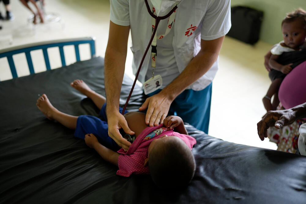An MSF doctor examines a young boy who has been unwell for two weeks, but because of the distance involved and lack of motorboat fuel has only now reached care