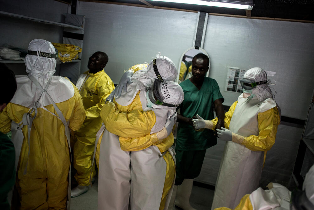 Health workers embrace while putting on their personal protective equipment before heading into the red zone at a newly built, MSF-supported Ebola treatment centre in Bunia, Democratic Republic of Congo. 2018.