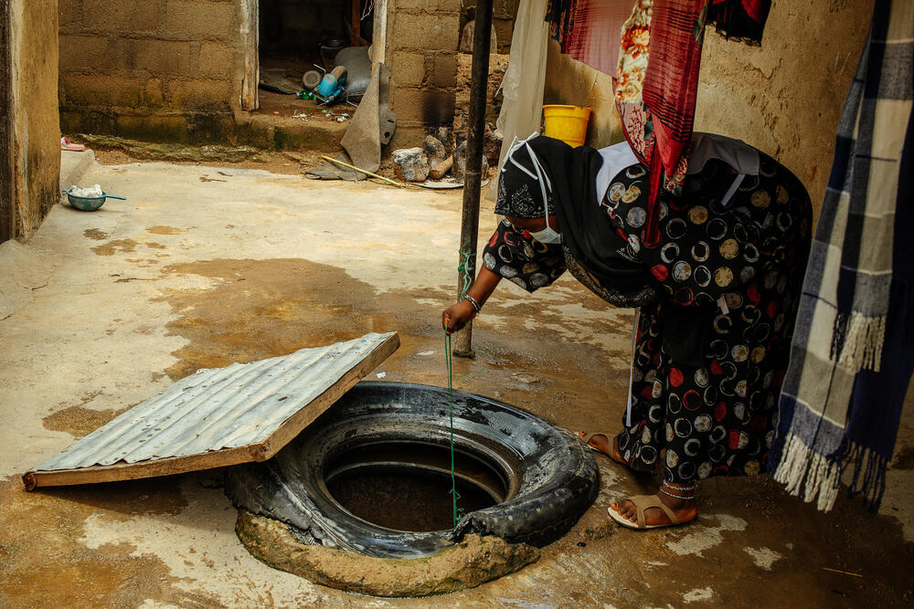 An MSF health promoter chlorinates a well in Magama village, Bauchi