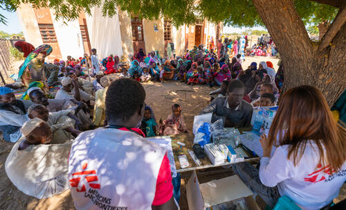 A group of returnees and refugees wait to receive a medical consultation at an MSF mobile clinic in Jerbana