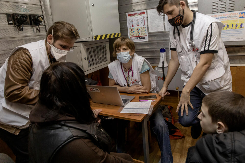 A mother and her 11-year-old son speak with a mobile clinic team in a Kharkiv metro station