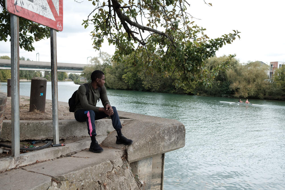 Yannick sits by a canal, close to MSF's Passerelle project in Paris