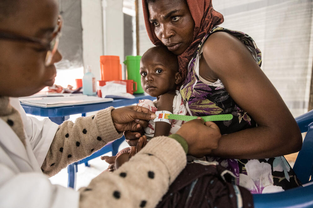 At an MSF clinic, Viviane - who fled her village in Masisi - has one of her children checked for signs of malnutrition