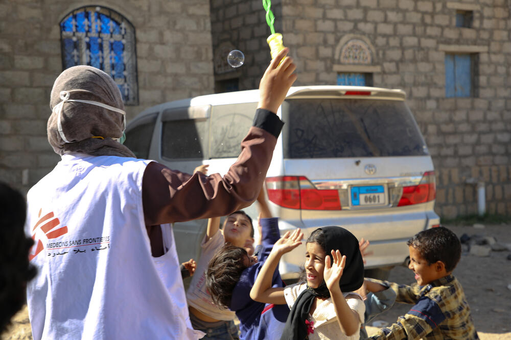 MSF health worker Sanaa playing a game with children displaced to Al Noor camp in Marib