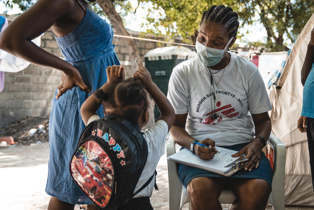 MSF health promotor, Germitha Journel, talks with a mother and her child in Parc Celtique displaced persons camp in Solino, Port-au-Prince, Haiti.