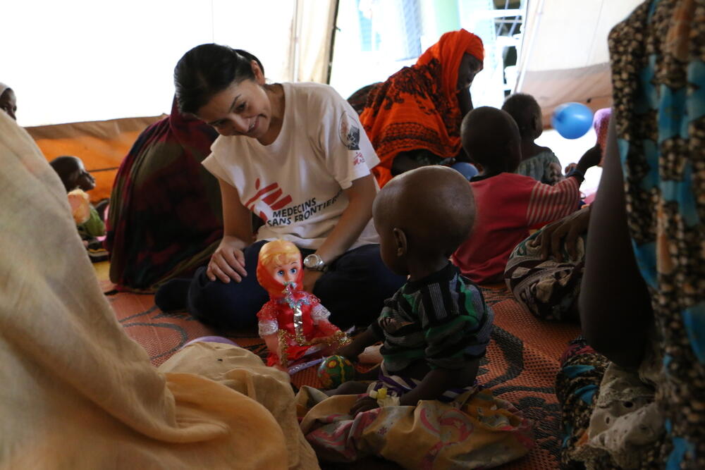 Aya Sonoda, MSF's information and education coordinator, plays with a child during a session of physical and emotional stimulation.