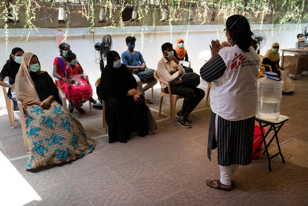 A health promoter demonstrates a safe handwashing technique to a group of patients waiting at an MSF clinic