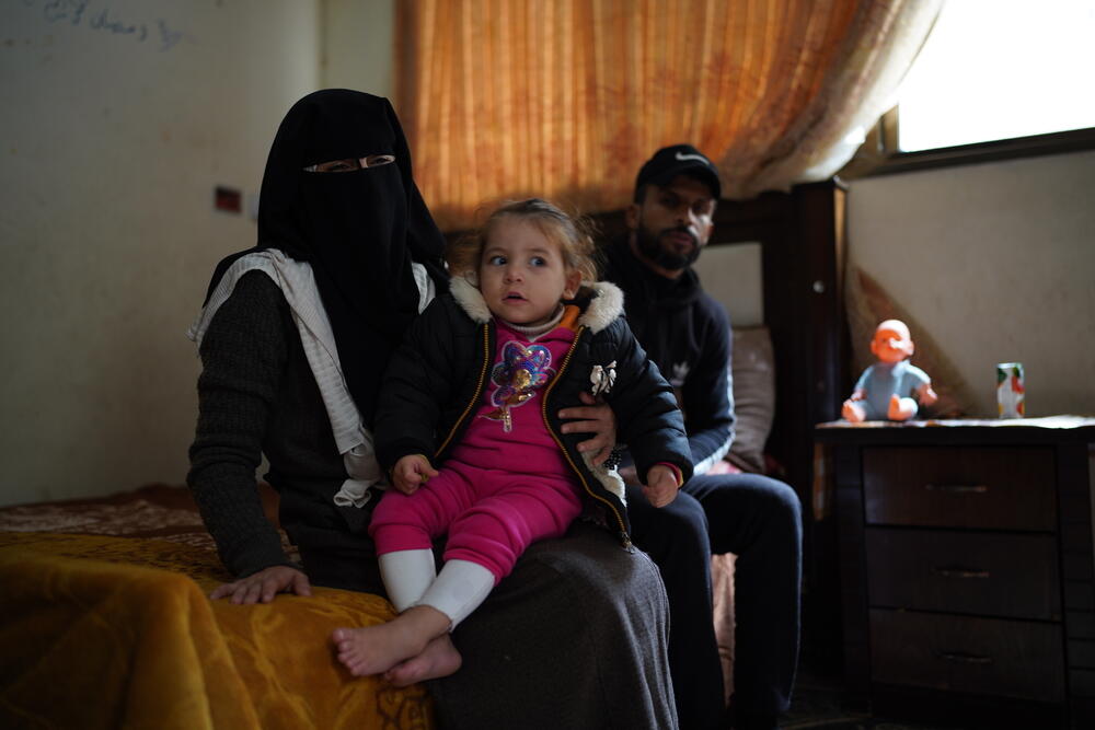 Two-year-old Sham, an MSF burns patient, sits with her parents in the room where the family live at Khan Younis refugee camp