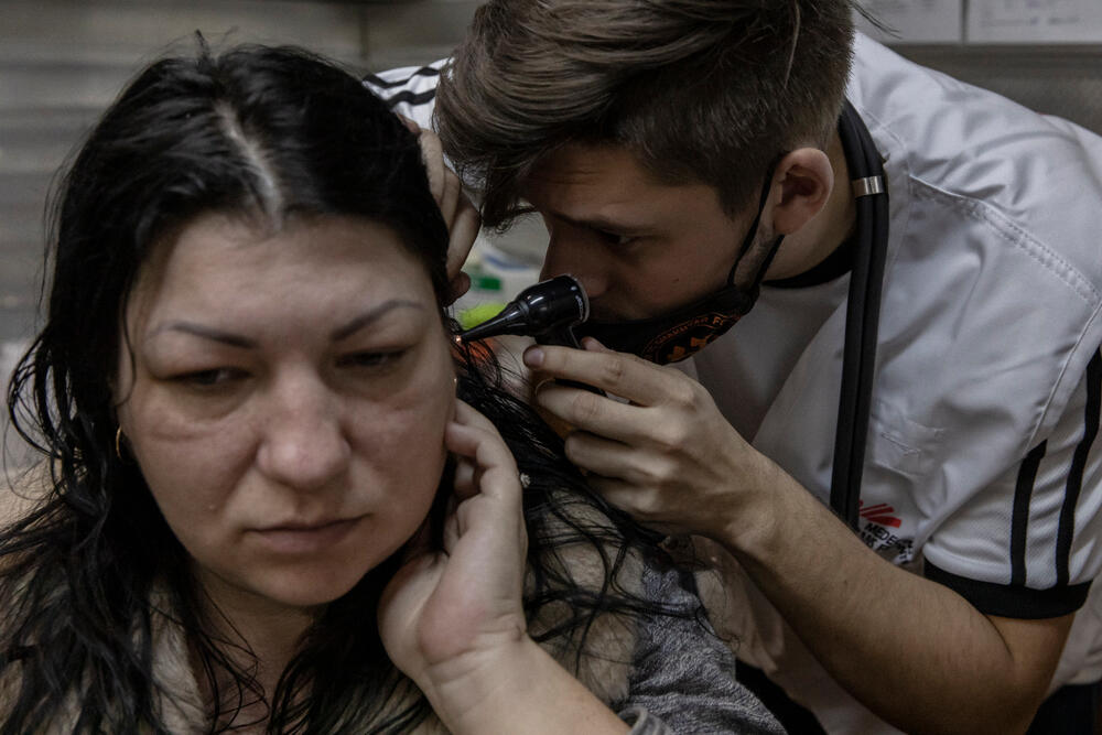 A Ukrainian medical student now working for MSF examines Kharkiv resident Elena