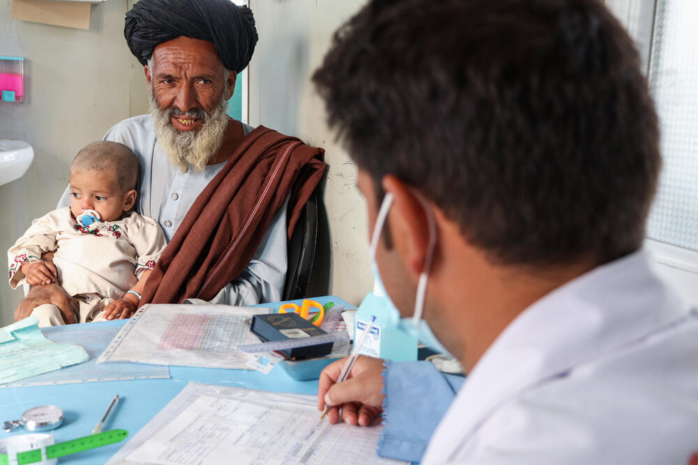 A grandfather brings his grandson, Mustafa, to the MSF Ambulatory Therapeutic Feeding Centre in Kandahar, Afghanistan 2022.