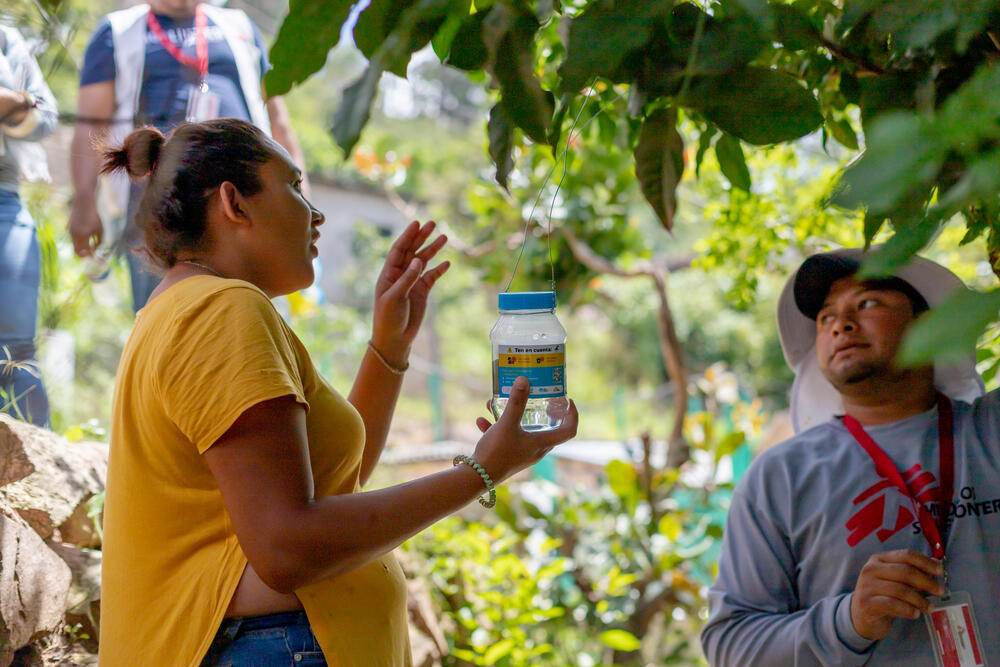 Local resident Julia López and Alex, an MSF health promoter, choose a spot to hang the Wolbachia mosquito eggs outside her home.