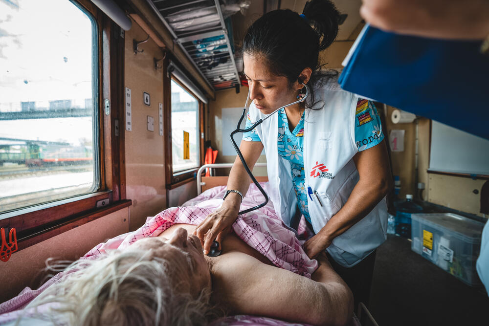 An MSF doctor monitors the condition of a patient on board a medical evacuation train travelling from Pokrovsk to Livi