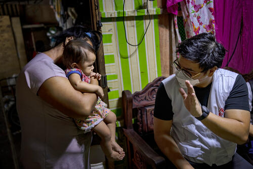 An MSF staff member conducting contact tracing at a household with a mother and her baby An MSF staff member conducting contact tracing at a household with a mother and her baby