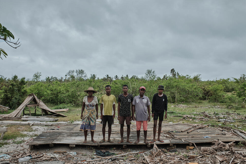 Fisherman Andriamanantena Tsiva Aurélien, who was injured in a cyclone, poses with his family surrounded by their destroyed village