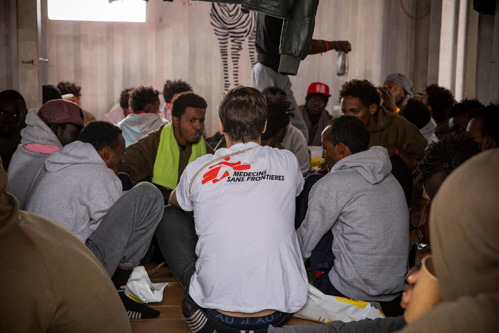 A humanitarian affairs officer speaks to rescued people as they come on board Ocean Viking, a search and rescue ship jointly operated by MSF and SOS MEDITERRANEE.