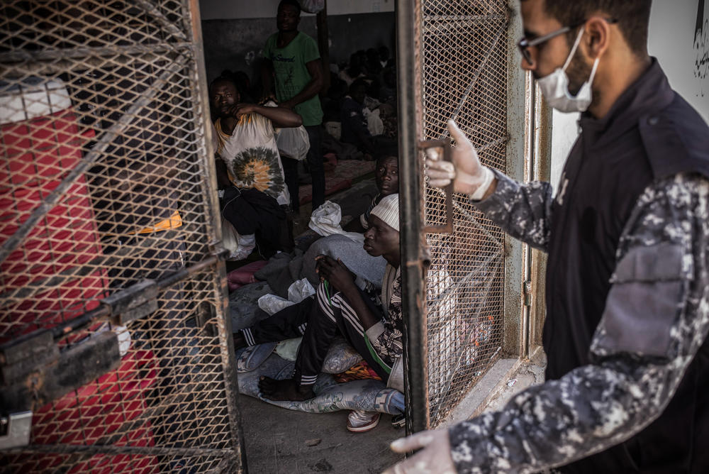 A guard shutting people in a detention centre cell in Tripoli, Libya, March 2017