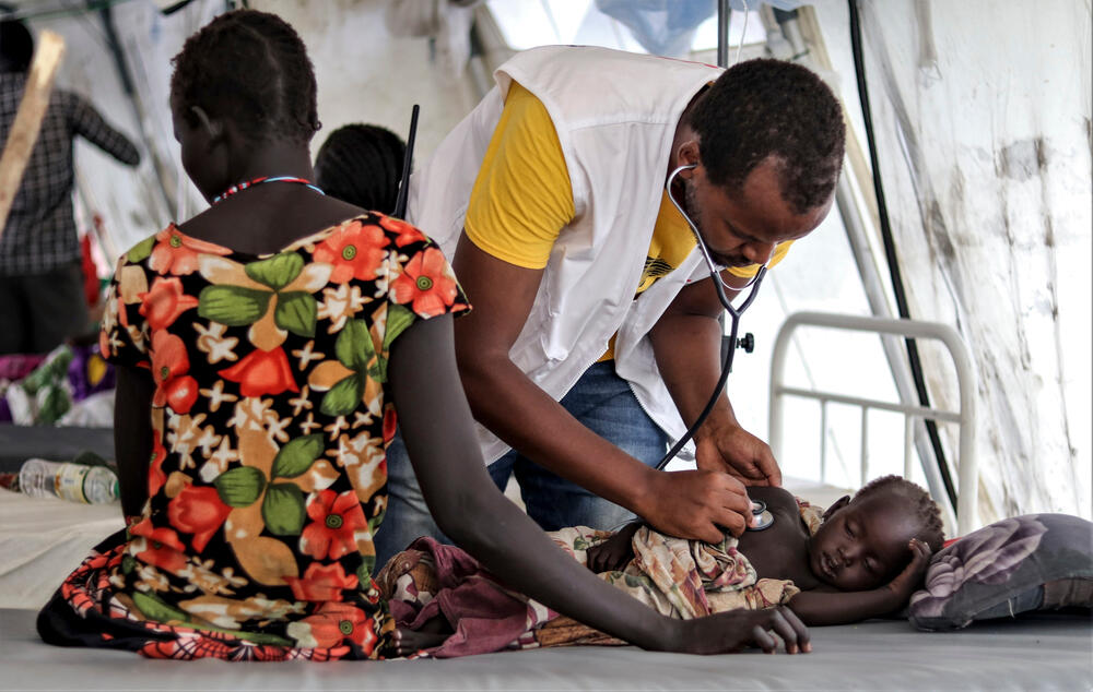 An MSF member of staff examines a child in MSF’s inpatient unit in Pibor town. September 2020.