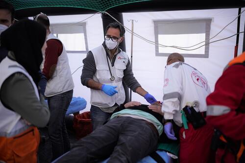 An MSF doctor assesses a patient at a trauma point run by the Palestinian Red Crescent Society