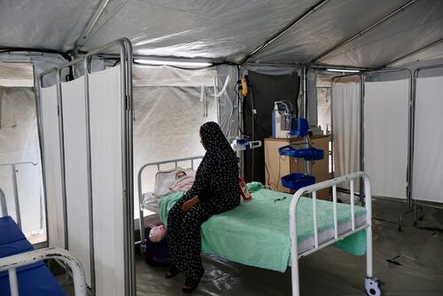 At an MSF field hospital in Deir Al Balah, Faten sits with her baby boy who is being treated for a severe respiratory infection