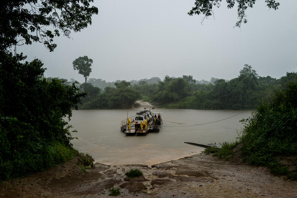 MSF vehicles ride the cable ferry to cross the river on the way to Nzacko