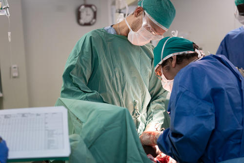 Surgeon John Buckles and medical doctor Martijn Knap perform a laparotomy on 10 years old Nyaduoth. Nyaduoth suffered several stab wounds and was transferred from Lankien to the MSF hospital in Bentiu Protection of Civilians (PoC) site to undergo surgery.