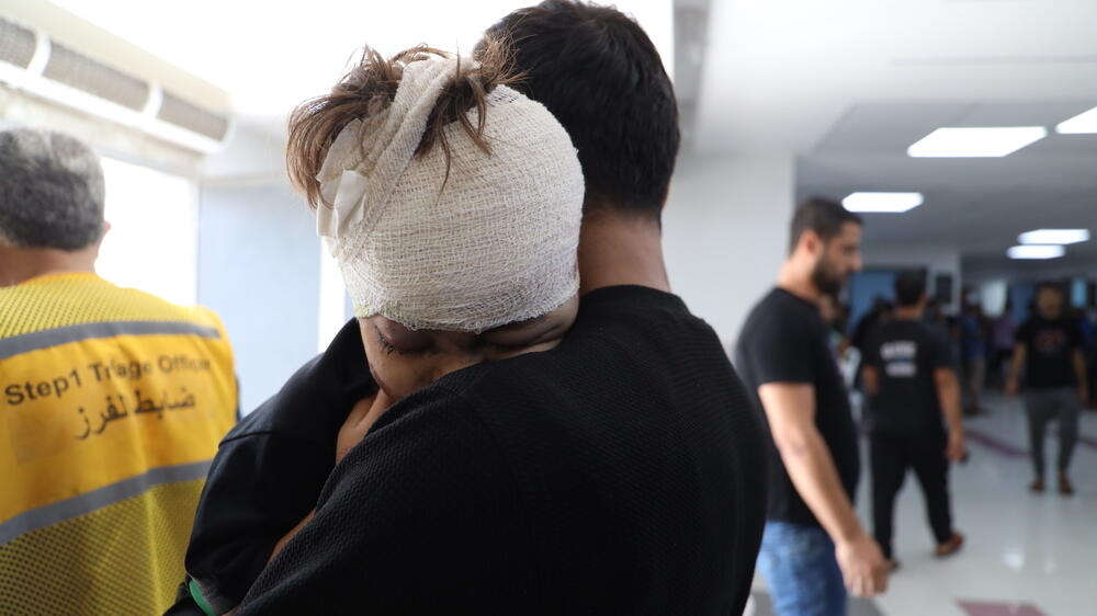 A young boy injured by an airstrike in Gaza hugs his father after receiving treatment at Al Shifa hospital