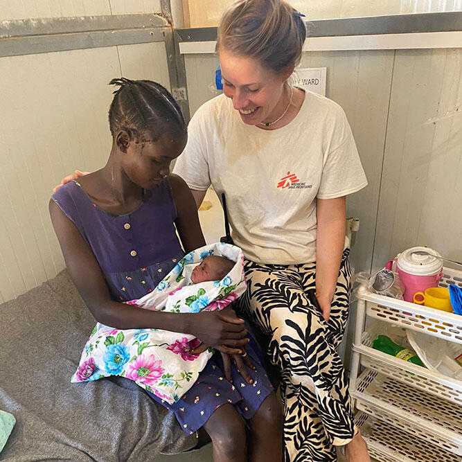 A mother and MSF medic sit with a new arrival at Bentiu