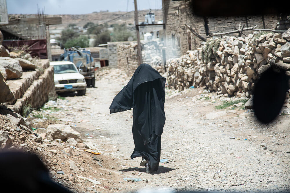 A woman walking through the streets of Huth, where MSF supports a healthcare centre