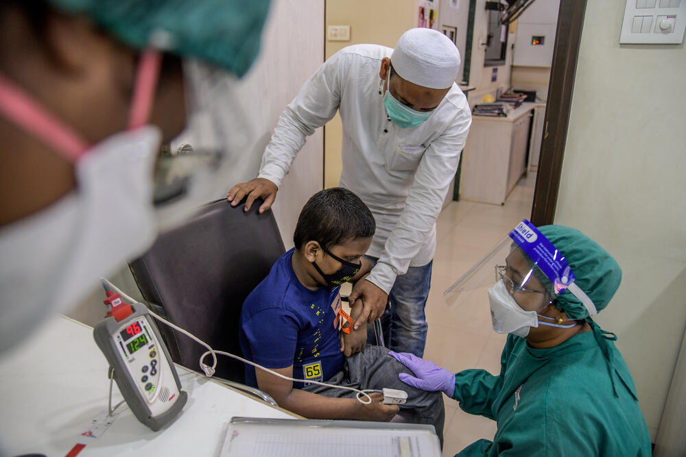 An MSF nurse taking TB samples from a young boy at a clinic in Mumbai
