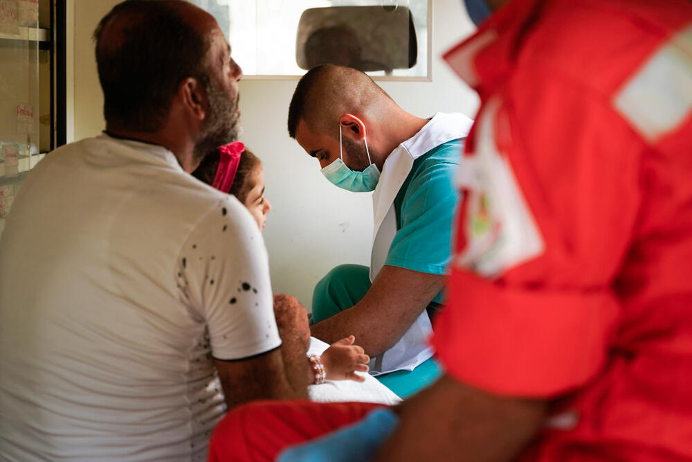 An MSF medic treating a three-year-old girl and her father, both wounded in the blast