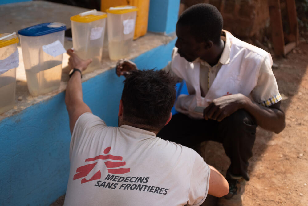 MSF staff control the quality of water prior to installing large water tankers in Ndu, DRC.