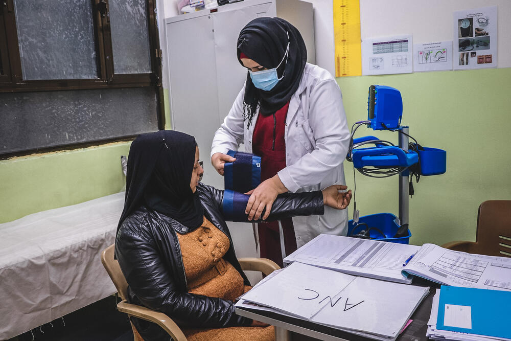 An MSF midwife at the Al-Amal maternity unit checks the blood pressure of Mariam who is pregnant with her third child